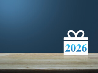 Gift box happy new year 2026 flat icon on wooden table over light blue wall, Business 2026 shop online concept