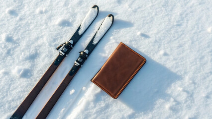 Ski equipment and a brown wallet resting on fresh snow