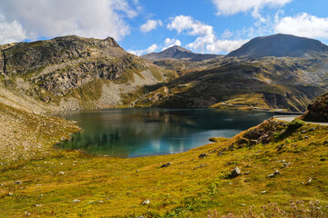 Pristine turquoise water reflects the summer sunlight in a remote glacial valley high above the timberline in the wild mountains