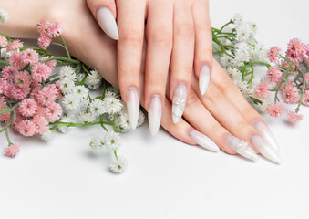 Fototapeta premium Woman showing hands with long white ombre nails