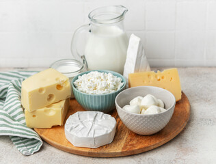 Assortment of fresh dairy products on wooden board
