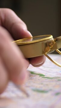Fingers grip compass above street map. Concept of solo traveler adventure. Route not fixed but imagined. Each path hides new stories behind corners and city borders