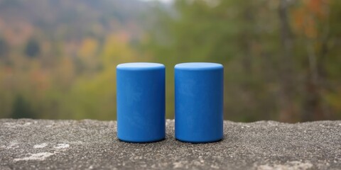 Two blue cups on a concrete surface