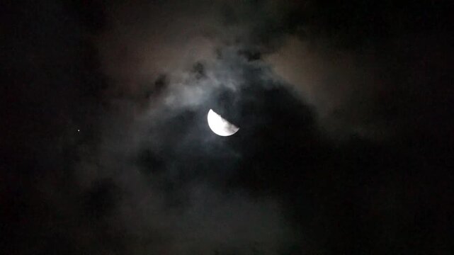 不気味な半月と流れ雲　不安を誘う闇夜の空