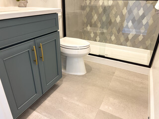 Bathroom vanity with gold hardware and tile shower