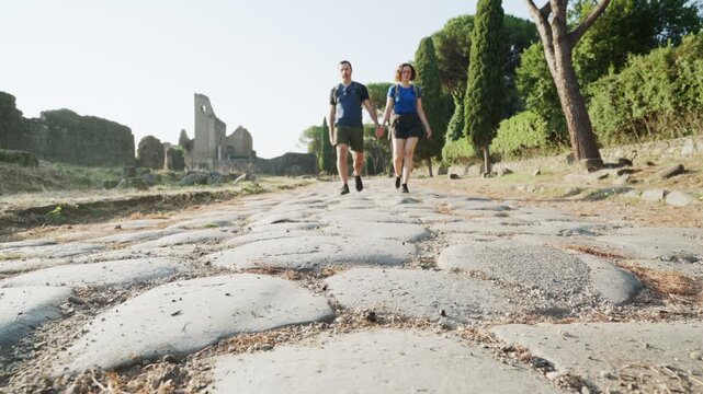 Romantic couple walking along the ancient Appia Antica in Rome