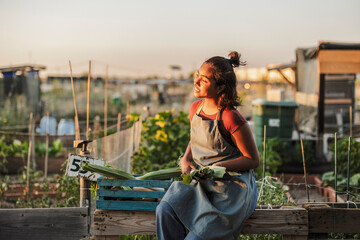 Young woman enjoying harvest in urban community garden