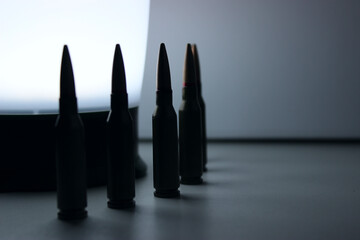 Live ammunition lined up in a semicircle around a portable lamp selective focus  stock photo 