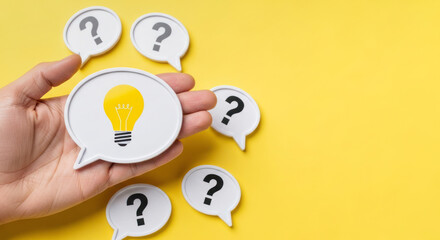 Hand holding a speech bubble with a light bulb symbol, surrounded by question mark speech bubbles on a vibrant yellow background, representing ideas and creativity in communication