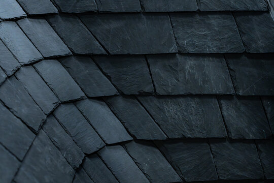 Gros plan sur une toiture en ardoise sombre, mettant en valeur la texture naturelle et l&rsquo;alignement des tuiles dans une couverture traditionnelle.