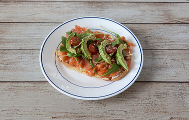 Smoked salmon avocado toast with fresh arugula and cherry tomatoes