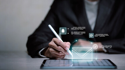 Businessman using stylus pen on digital tablet with virtual email and notification icons.