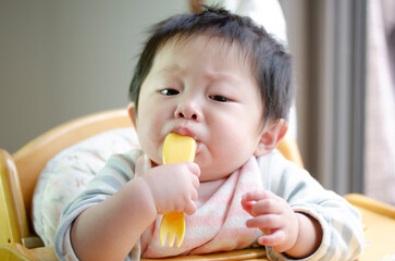 フォークを口に入れる赤ちゃん