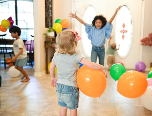 Fototapeta premium Children celebrating indoors with balloons and joyful energy.