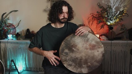 Playing a hand drum in a cozy indoor space with decorative lights