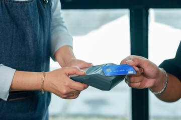 Close up hands asian restaurant owner customer using wireless terminal for credit card contactless payment showing modern technology transaction concept representing cashless small business service