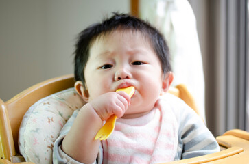 フォークを口に入れる赤ちゃん