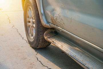 mud-splattered side of an SUV on concrete