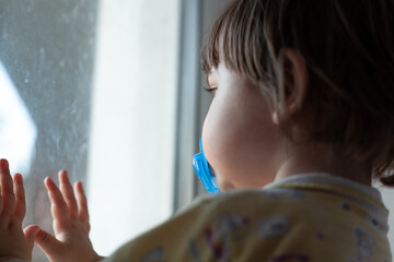 The child looks out the window