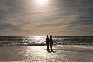 Carefree retired multiracial senior couple enjoying sunny day on shore at beach against sky