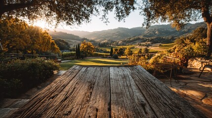 Textured wooden table overlooks a scenic vineyard valley at golden hour. Ideal for product display, travel blogs, or tranquil outdoor dining.