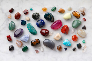 Colorful Tumbled Gemstones on White Marble Background