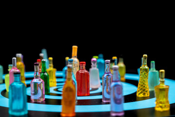 are various miniature resin bottles, likely dollhouse miniatures or novelty items, arranged on a surface with blue concentric circles