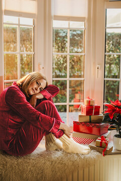 Cozy morning on windowsill with gifts and poinsettia during Christmas
