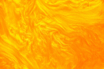 Shimmering gold abstract background. Liquid gold texture waves and swirls. Beautiful shiny yellow...