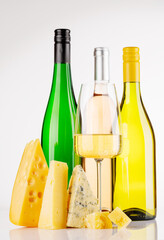 Assorted cheeses and wine on white background