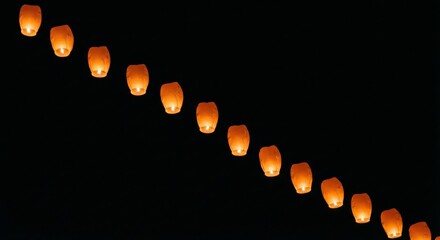 Sky lanterns floating in the night sky during a festival
