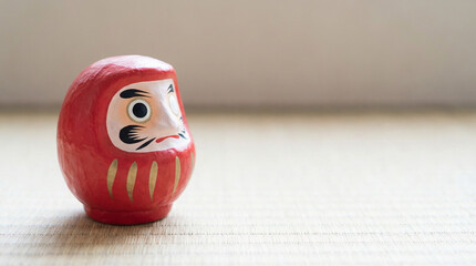 畳の上に佇む赤いだるまと願掛けの風景