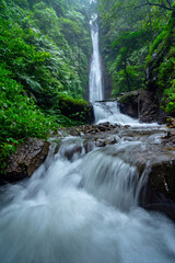 Obraz premium Captivating Cakung Waterfall Cascading Through Lush Greenery in Mojokerto, East Java, Indonesia