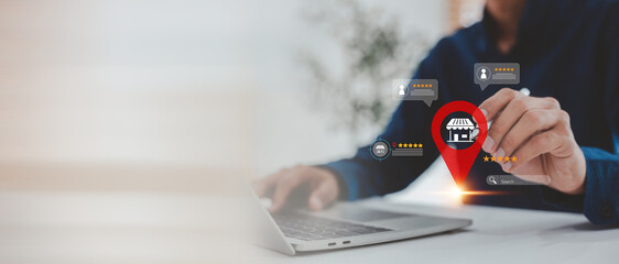 Man pointing at a store location pin icon with rating stars and customer reviews on a virtual screen over his laptop, symbolizing local business search, reputation management, and online .