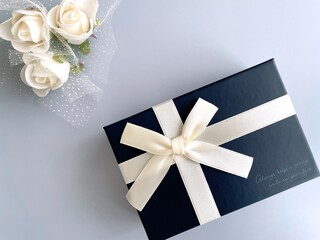 Elegant gift box and white flowers on a light blue background