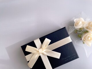 Elegant gift box and white flowers on a light blue background