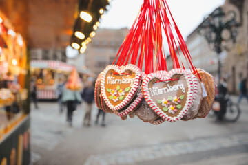 Heart shaped gingerbread cookies with nurnberg text and floral icing designs hanging from red...
