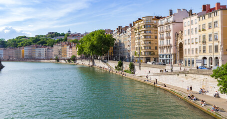 Panoama of people enjoying the spring weather at the riverbank in Lyon, France