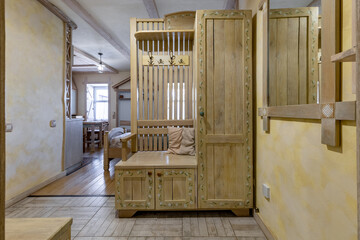 Rustic entryway interior with handcrafted wooden furniture and floral painting