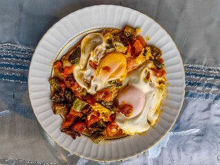 Tomatoes, saut&eacute;ed, and topped with eggs fried in oil.