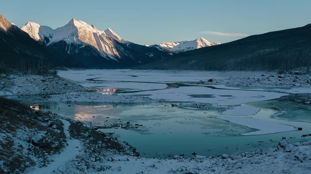 Winter sunset time lapse of frozen Medicine Lake in Jasper National Park, Canada.