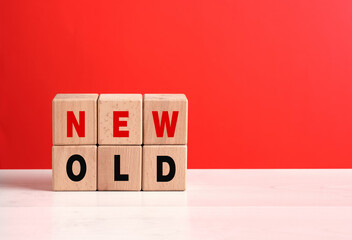 Wooden Cubes Showing New Versus Old on Red Background