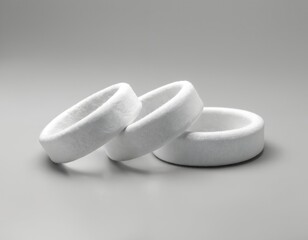 Three blank white fabric wristbands stacked on a grey surface. These event bands are ready for custom printing with logos or designs. They are perfect for festivals concerts and corporate gatherings.