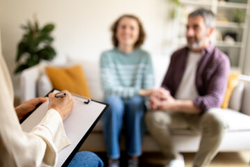 Therapist taking notes during couple counseling session