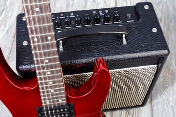 Red electric guitar resting on a sound amplifier