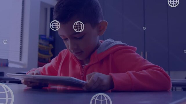 Multiple web globe icons floating over boy using digital tablet in the class at school