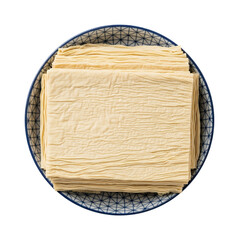 Tofu skin sheets (fresh yuba) folded into wide rectangular layers and stacked neatly inside a round ceramic bowl