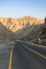 Mountain road background with a stunning view of Jebel Jais under a cloudy sky, a beautiful travel destination in Ras Al Khaimah.