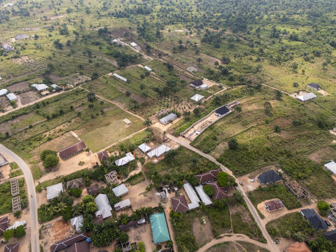 Aerial view of scattered buildings and lush vegetation intermingle in a tapestry of green and brown, revealing the serene landscape, Egbema, Rivers, Nigeria.