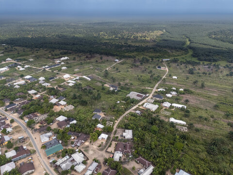 Aerial view of the humble buildings nestled amongst the lush greenery, with a dense forest stretching into the horizon, Egbema, Rivers, Nigeria.